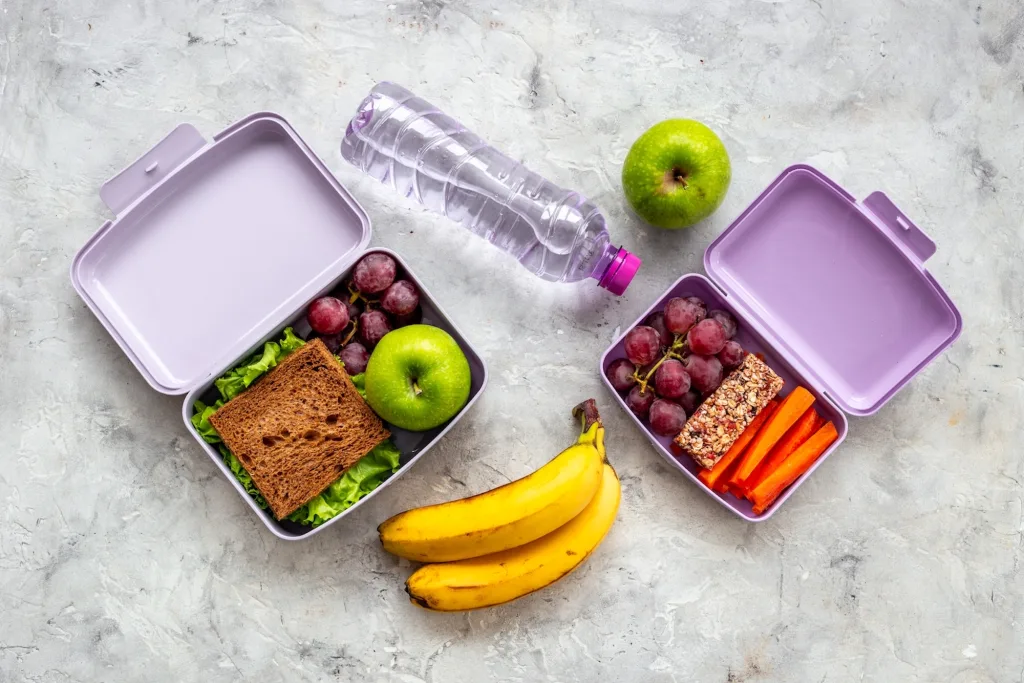 Lonchera con alimentos saludables como frutas, pan integral y yogurt.